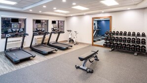 A gym with treadmills, an elliptical, a bench, and a rack of dumbbells. - Hampton Inn by Hilton Irvine East - Lake Forest (Foothill Ranch)