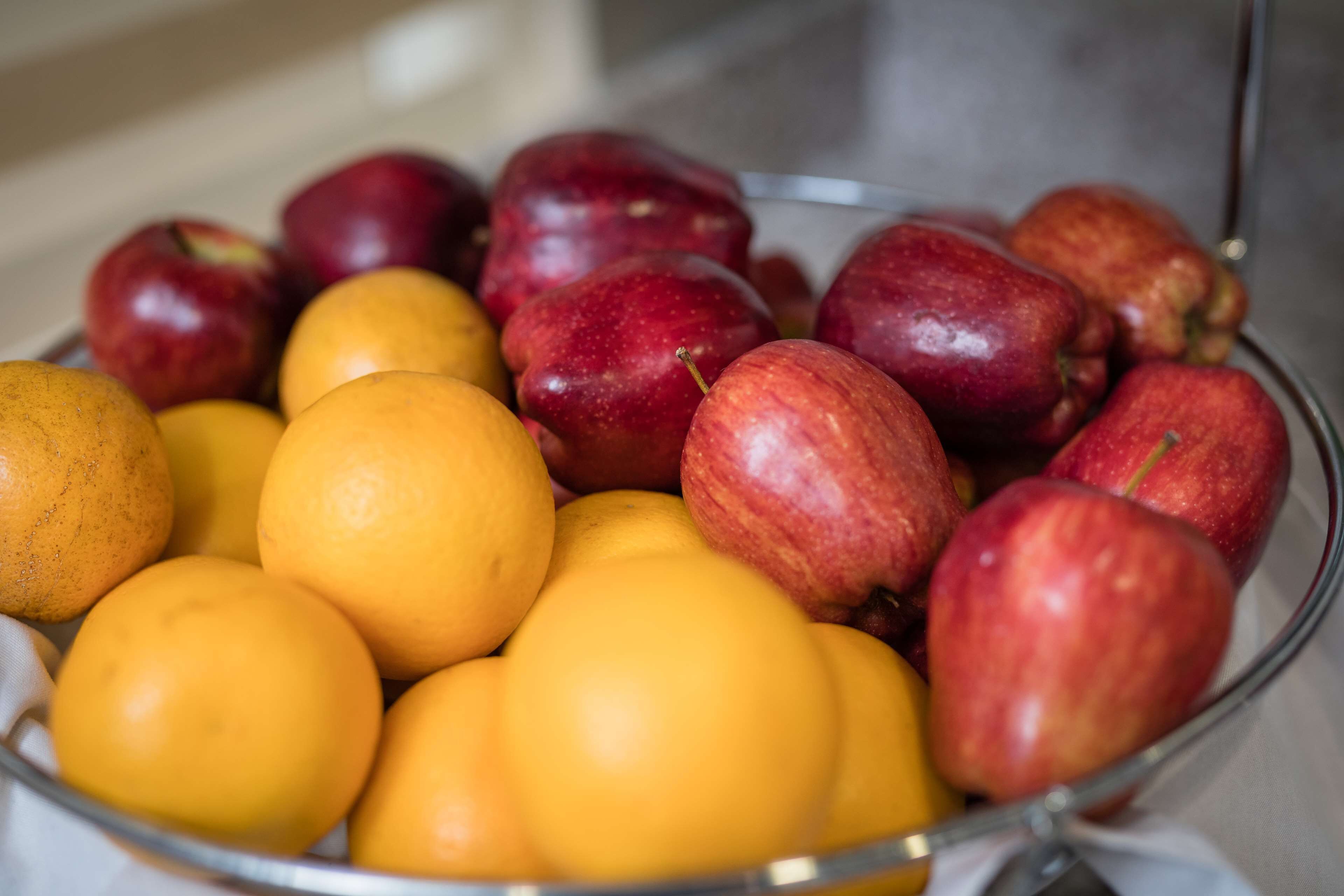 A bowl containing apples and oranges.
