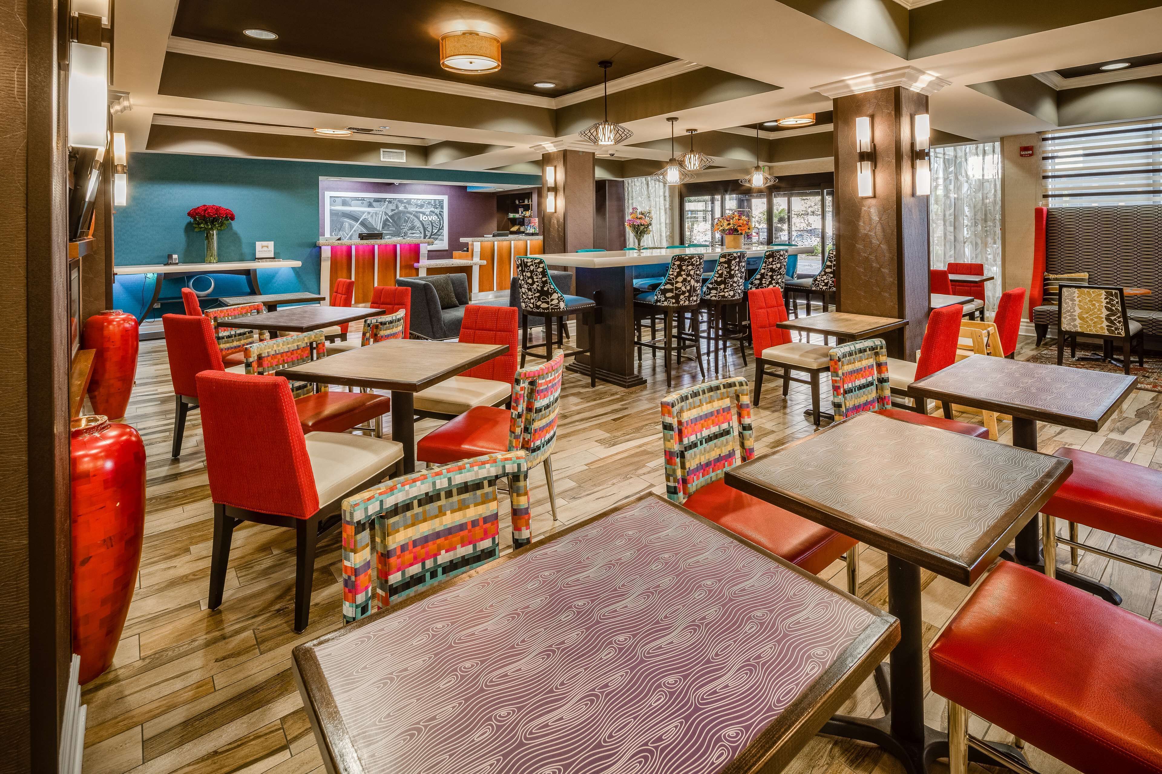 A restaurant with multiple tables and chairs, a bar area, and a counter.