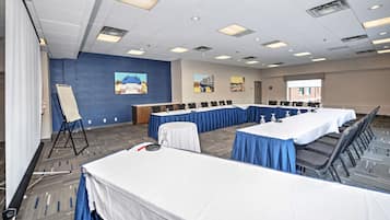 Une salle de conférence équipée d’une longue table, de chaises et d’un écran de projection.