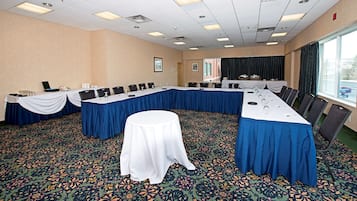 Une salle de conférence avec une longue table, des chaises et une petite table au centre.