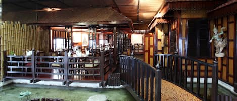 Un intérieur de style japonais traditionnel, avec un sol recouvert de tatamis, des meubles en bois et un élément décoratif aquatique.
