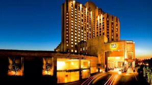 A high-rise hotel with multiple floors and a well-lit entrance. - The LaLiT New Delhi (New Delhi)