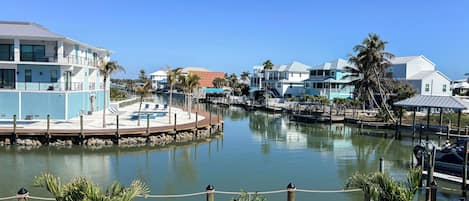 A waterfront property with a dock, a white picket fence, and a clear blue sky.