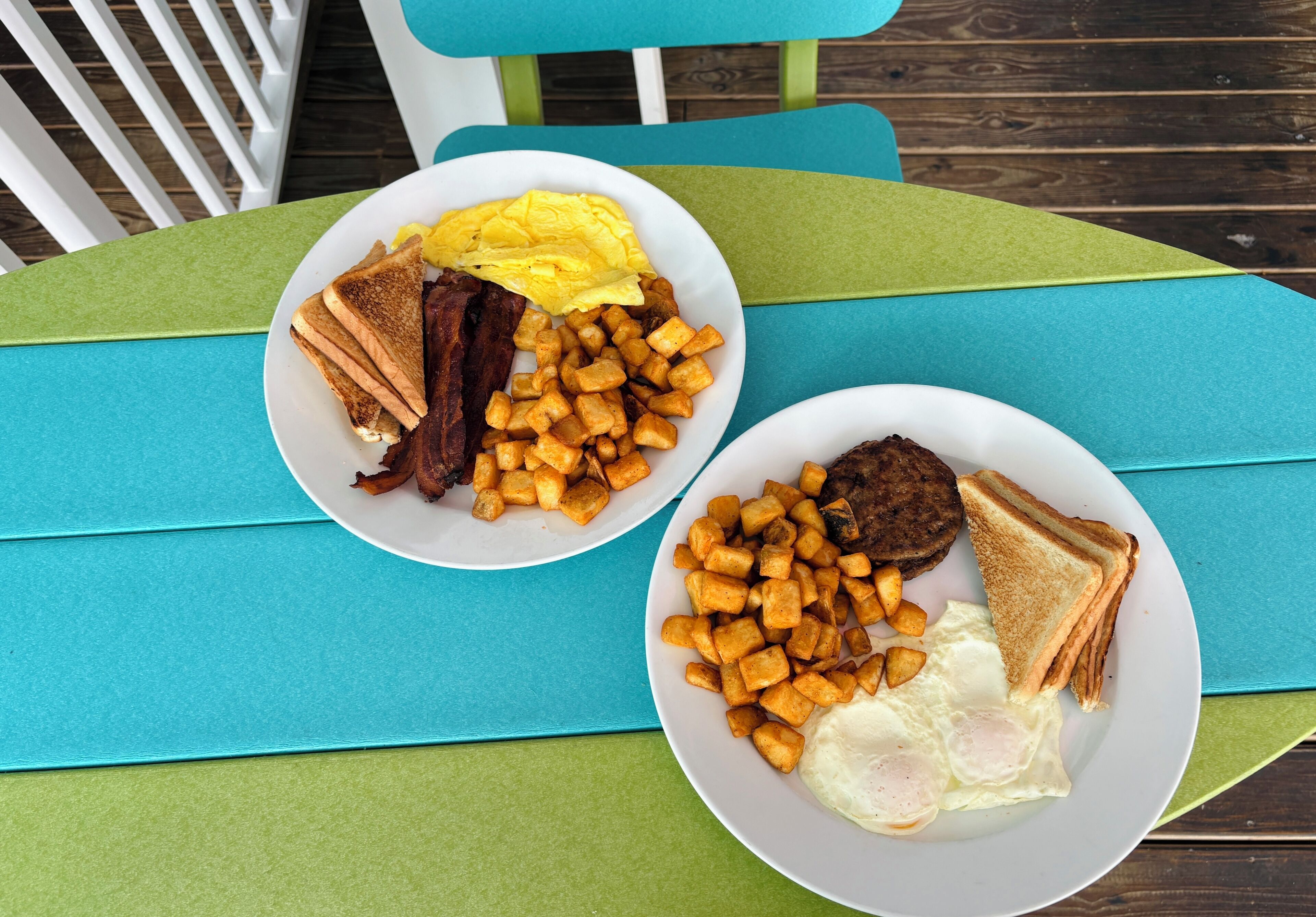 Deux assiettes de nourriture pour le petit-déjeuner sont posées sur une table aux couleurs vertes et bleues.