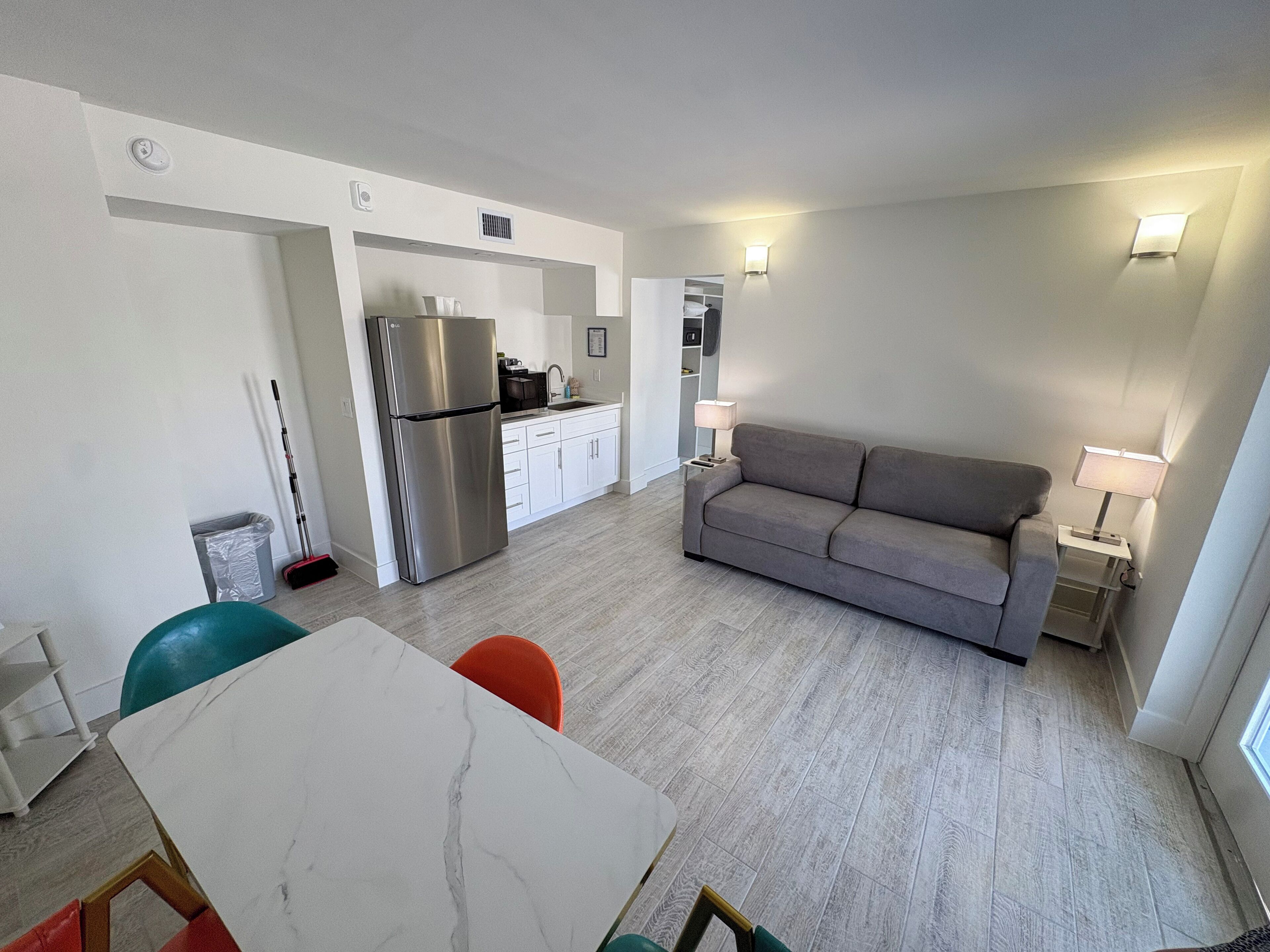 A compact living space with a kitchen, dining area, and a sofa.