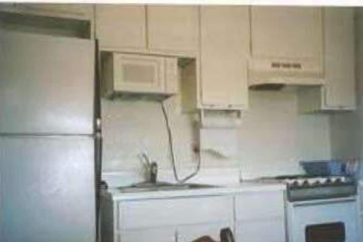 A kitchen with white cabinets, a microwave, and a stove.