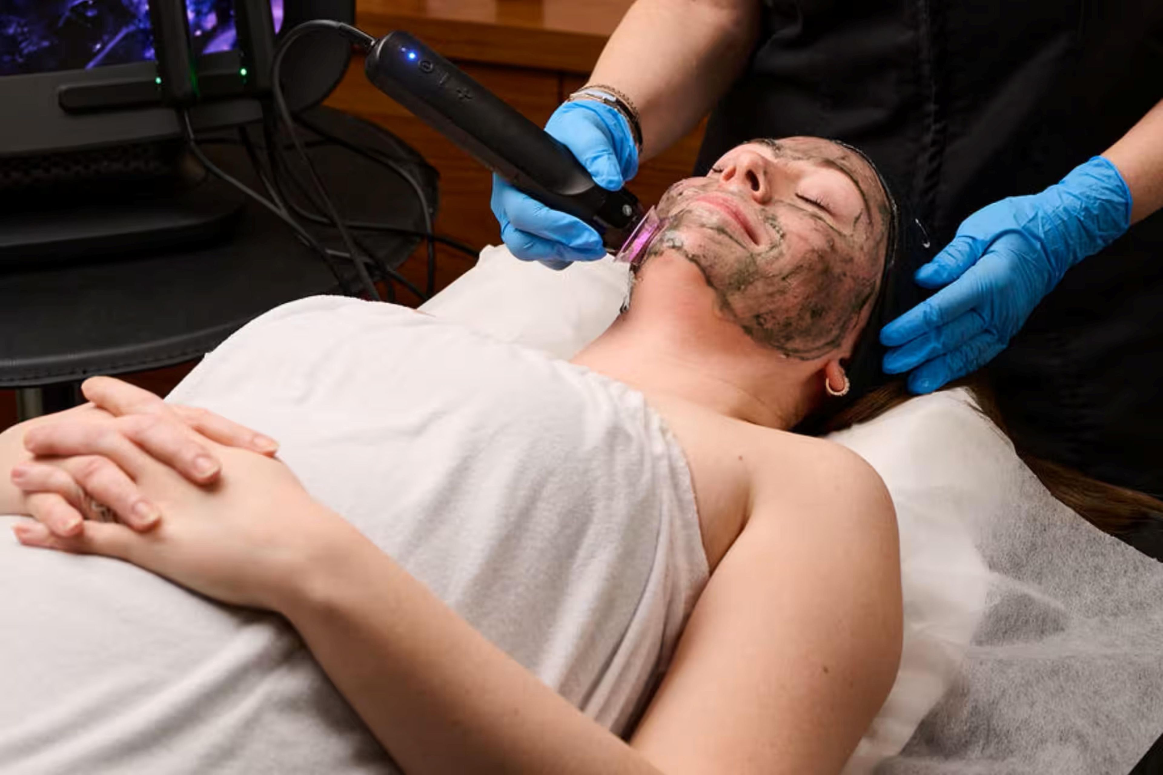 Una persona acostada en una cama con un dispositivo médico siendo utilizado en su rostro.