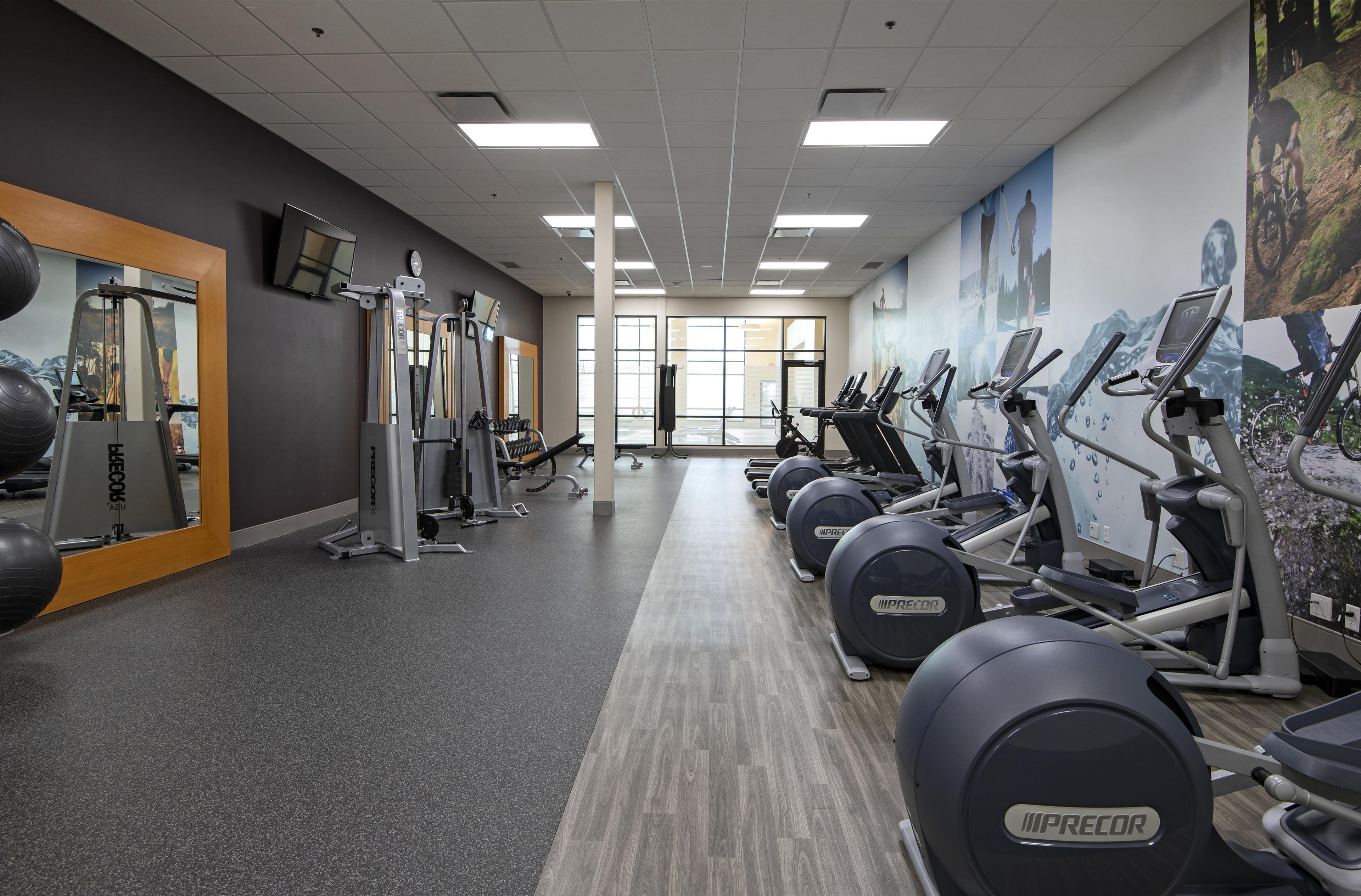 A gym with treadmills, elliptical machines, and weight equipment.