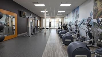 A gym with treadmills, elliptical machines, and weight equipment.