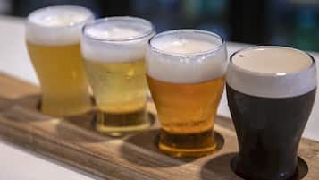 Quatre verres de bière sur un plateau en bois.