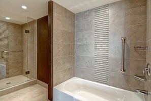 A modern bathroom with a glass-enclosed shower, a walk-in bathtub, and a vanity with a mirror. - DoubleTree by Hilton Hotel West Edmonton (Edmonton)