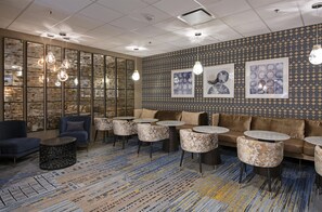 A modern lounge area with seating, tables, and artwork on the walls. - DoubleTree by Hilton Hotel West Edmonton (Edmonton)