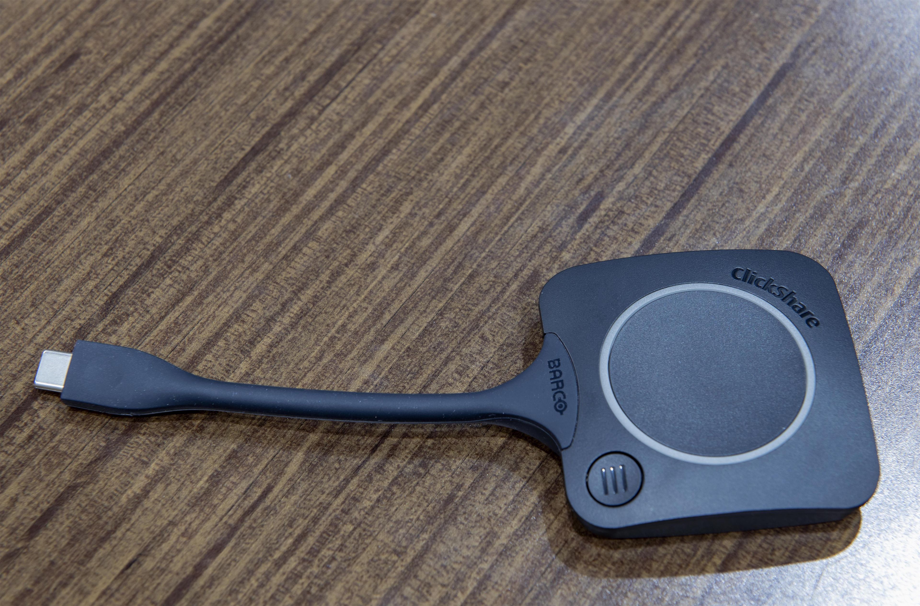 Un câble USB noir avec une molette de défilement sur une surface en bois.