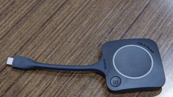 Un câble USB noir avec une molette de défilement sur une surface en bois.
