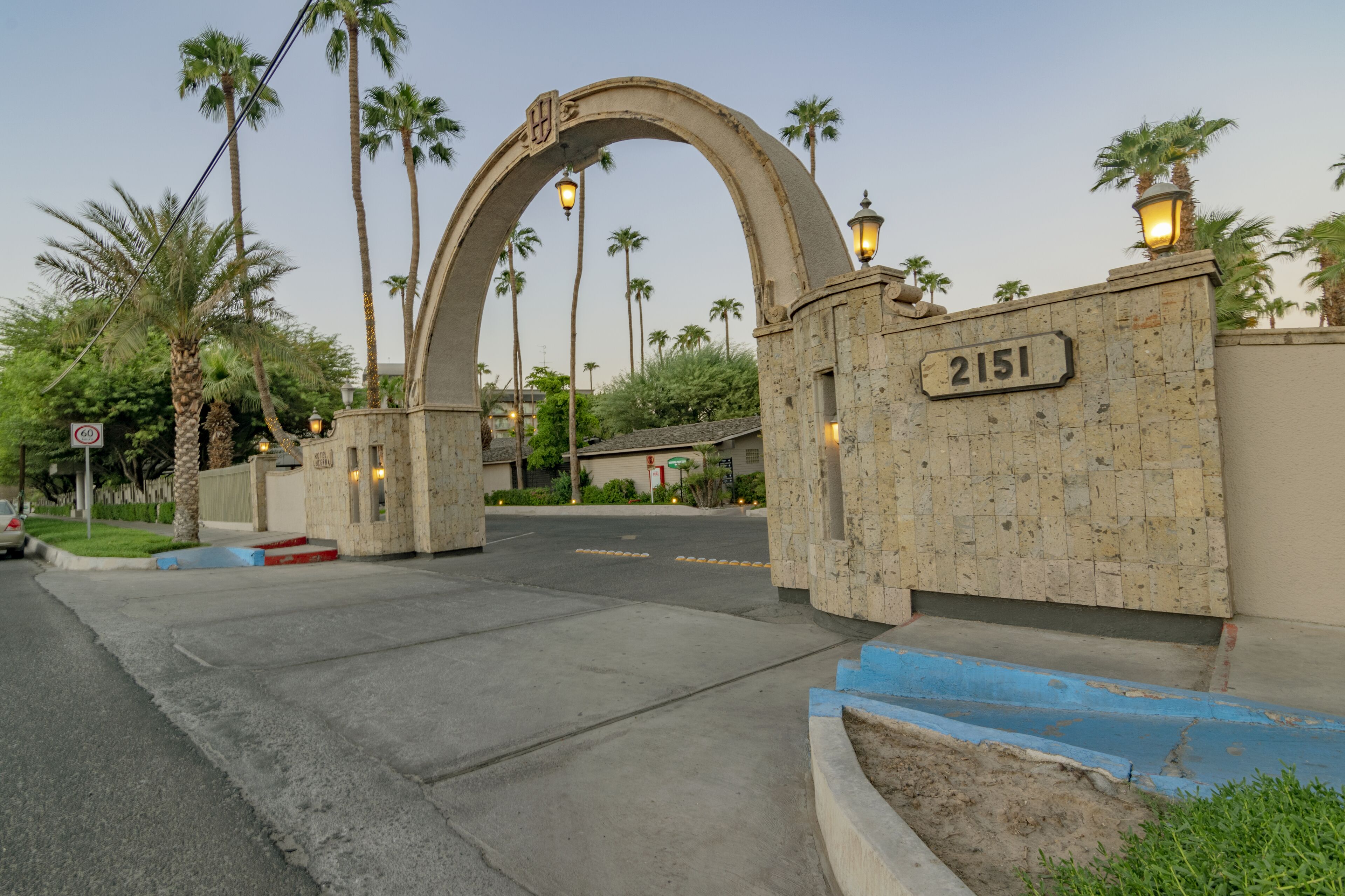 Una entrada protegida con arco de piedra y un cartel que muestra el número 2151.