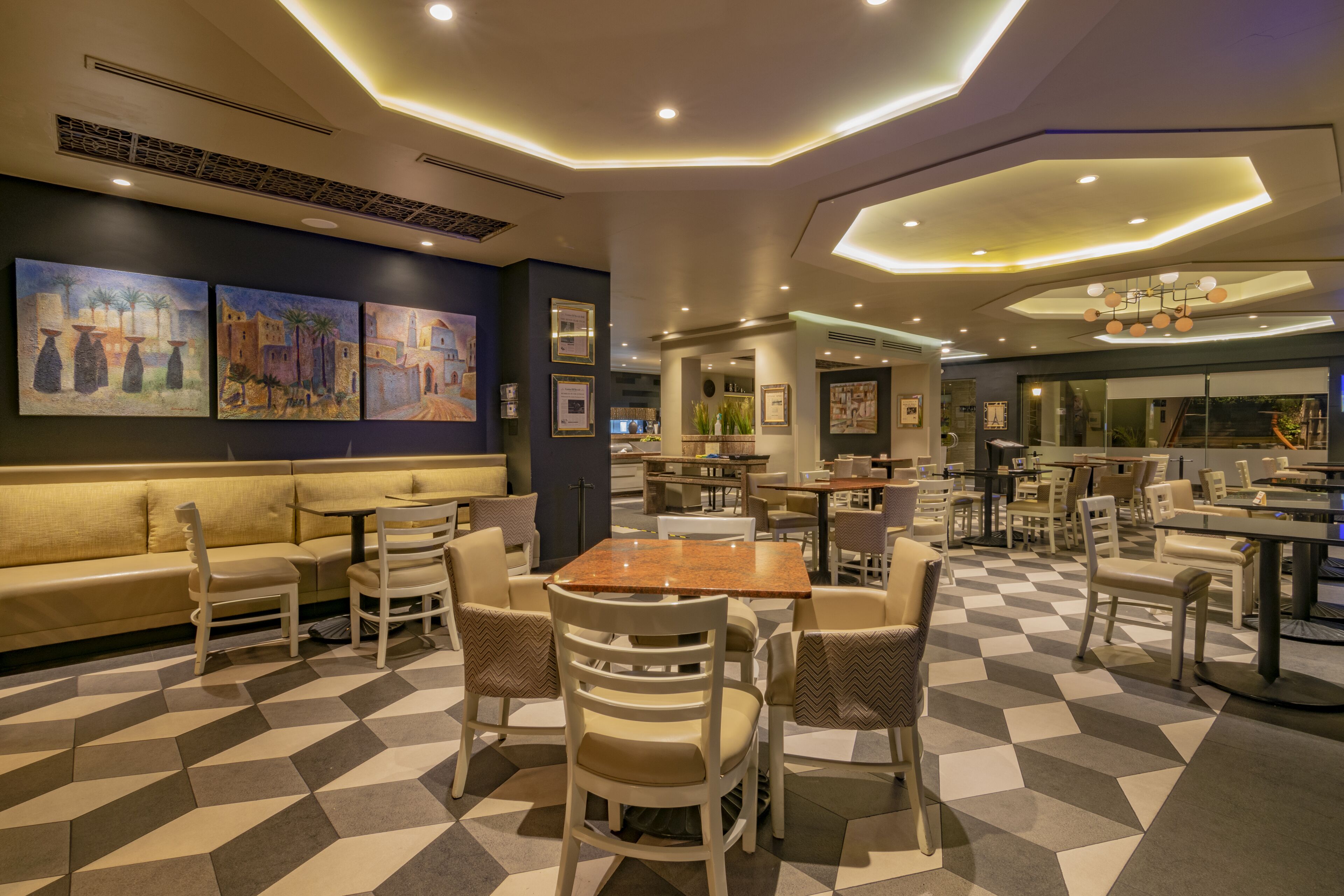 A modern restaurant with a checkered floor, cushioned seating, and contemporary decor.
