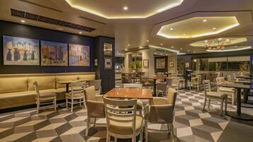 A modern restaurant with a checkered floor, cushioned seating, and contemporary decor.
