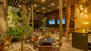 An indoor area with wicker furniture, a stone planter with rocks, and a bar area with a counter.