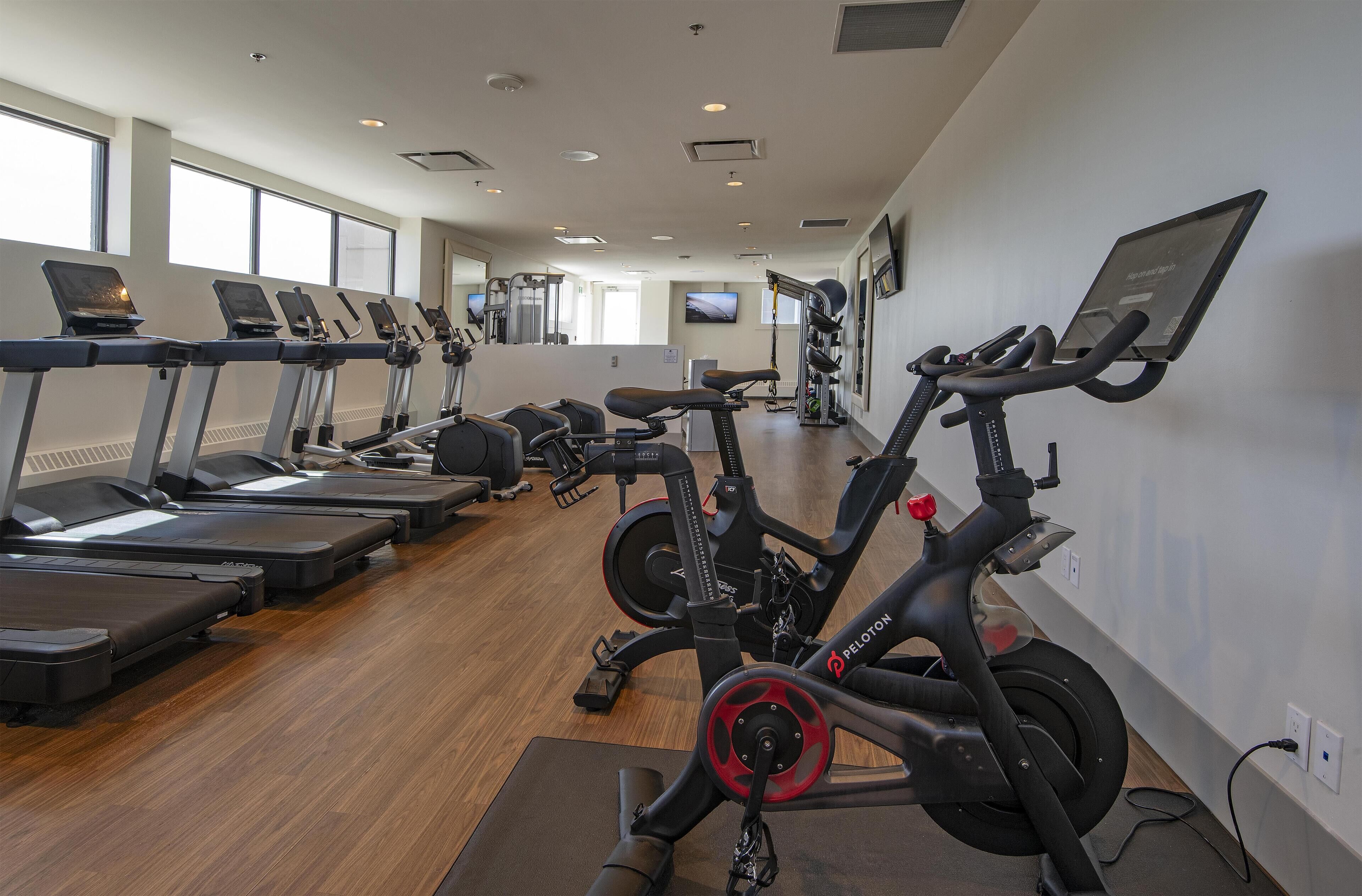 A gym with treadmills, stationary bikes, and exercise equipment.