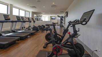 A gym with treadmills, stationary bikes, and exercise equipment.