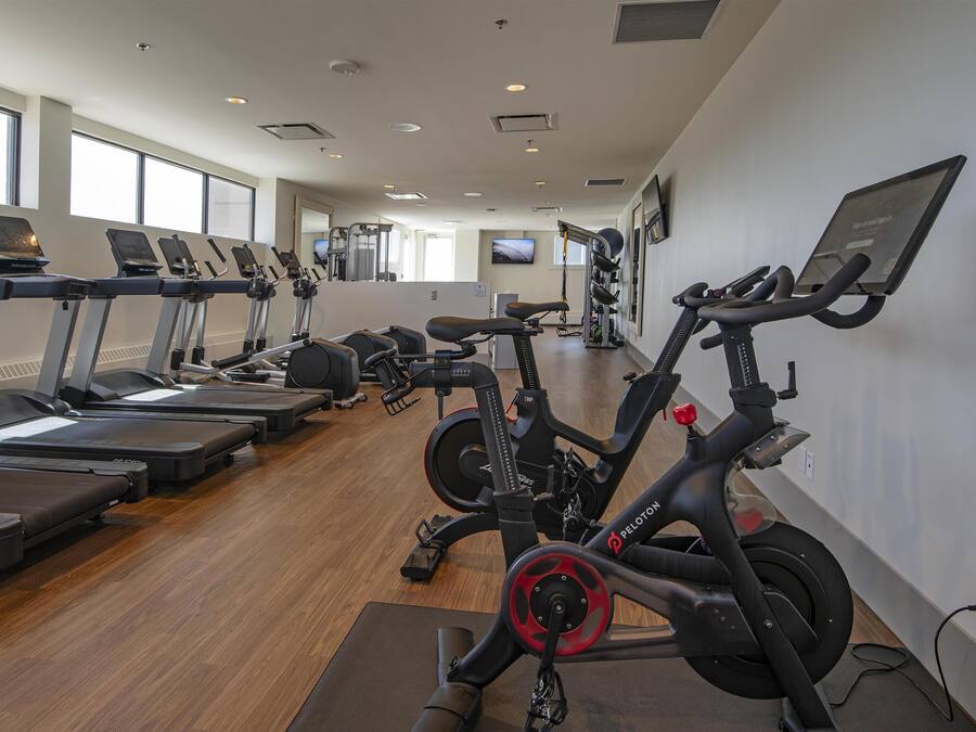 A gym with treadmills, stationary bikes, and exercise equipment.