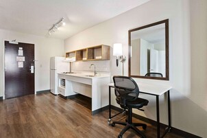 Escritorio, cortinas blackout y tabla de planchar con plancha