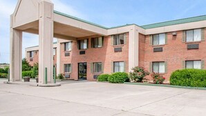 A hotel with a brick facade, multiple windows, and a covered entrance area. - Econo Lodge Dexter (Dexter)
