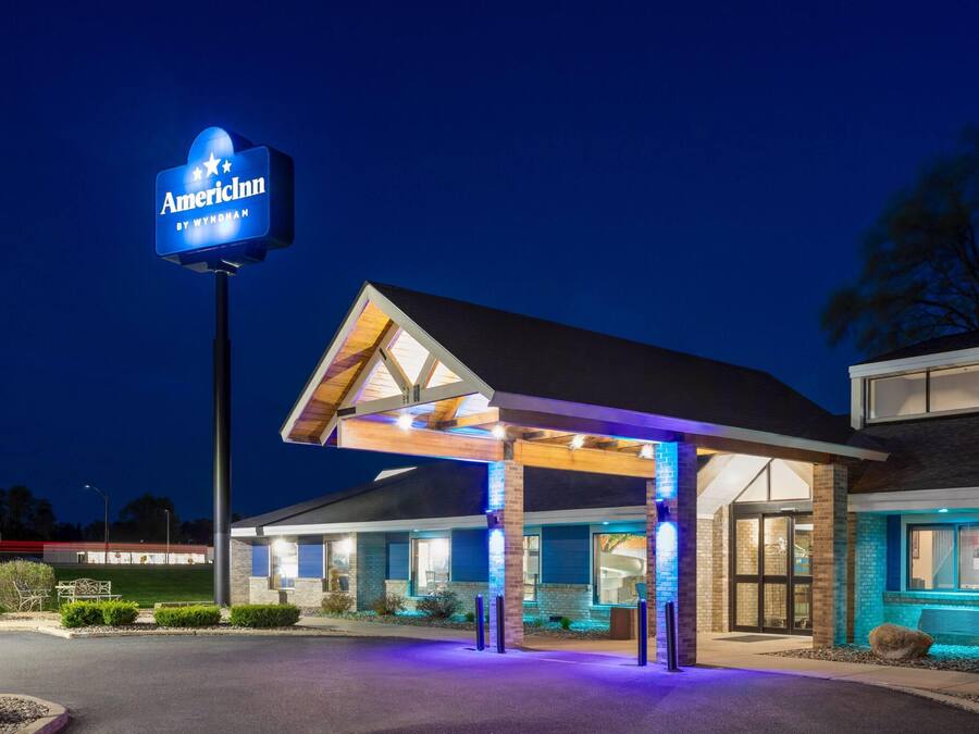 A hotel with a covered entrance, a prominent sign, and a well-lit facade.