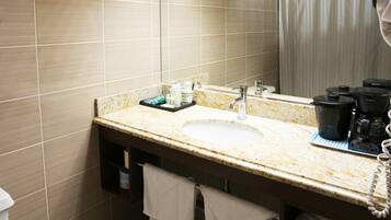 A bathroom with a sink, mirror, and shower curtain.