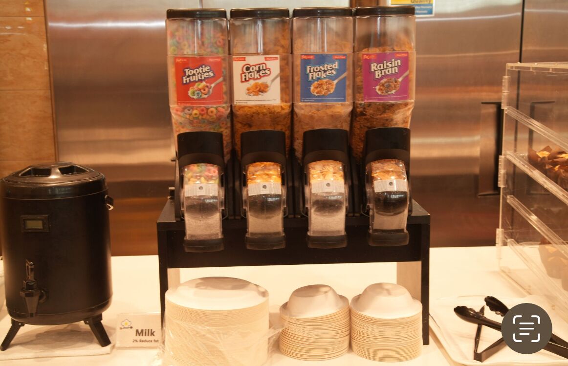 A beverage dispenser with four different flavors: Tootie Frutti, Corn Flakes, Frosted Flakes, and Raisin Bran.