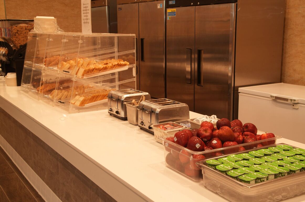 A buffet area with various food items including croissants, apples, and yogurt containers.