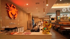 A restaurant interior with a crab decoration, a golden cat statue, and a counter with menus. - LA Crystal Hotel - Los Angeles Area (Compton)