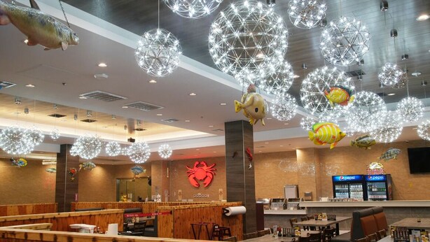 A restaurant interior with wooden booths, a counter, and hanging spherical light fixtures. - LA Crystal Hotel - Los Angeles Area (Compton)