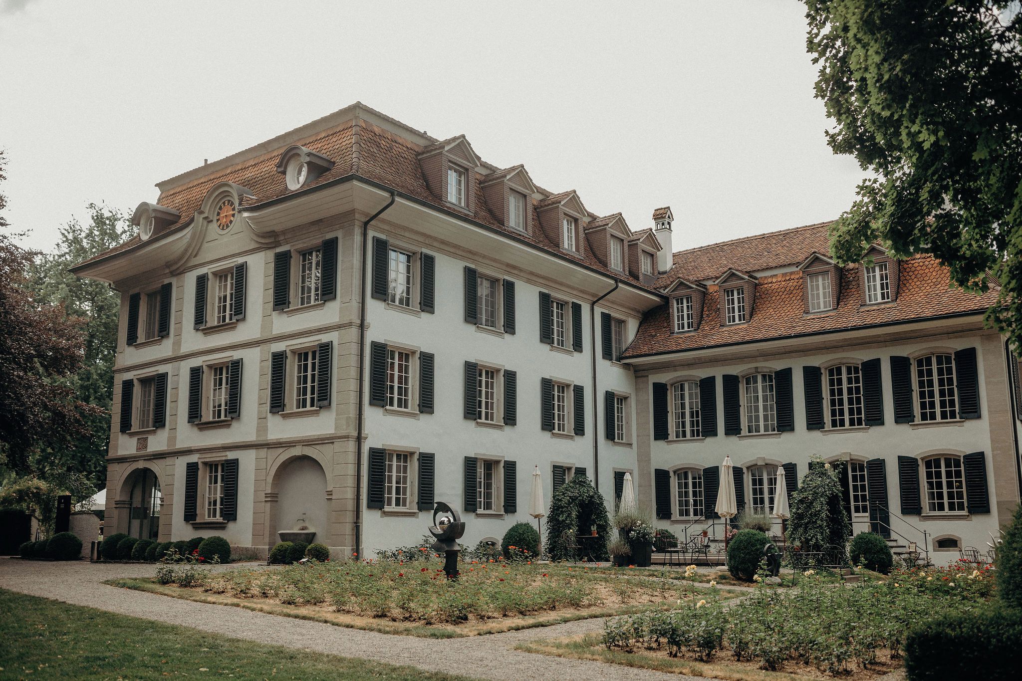 A multi-story building with a symmetrical facade, multiple windows with shutters, and a central arched entrance.