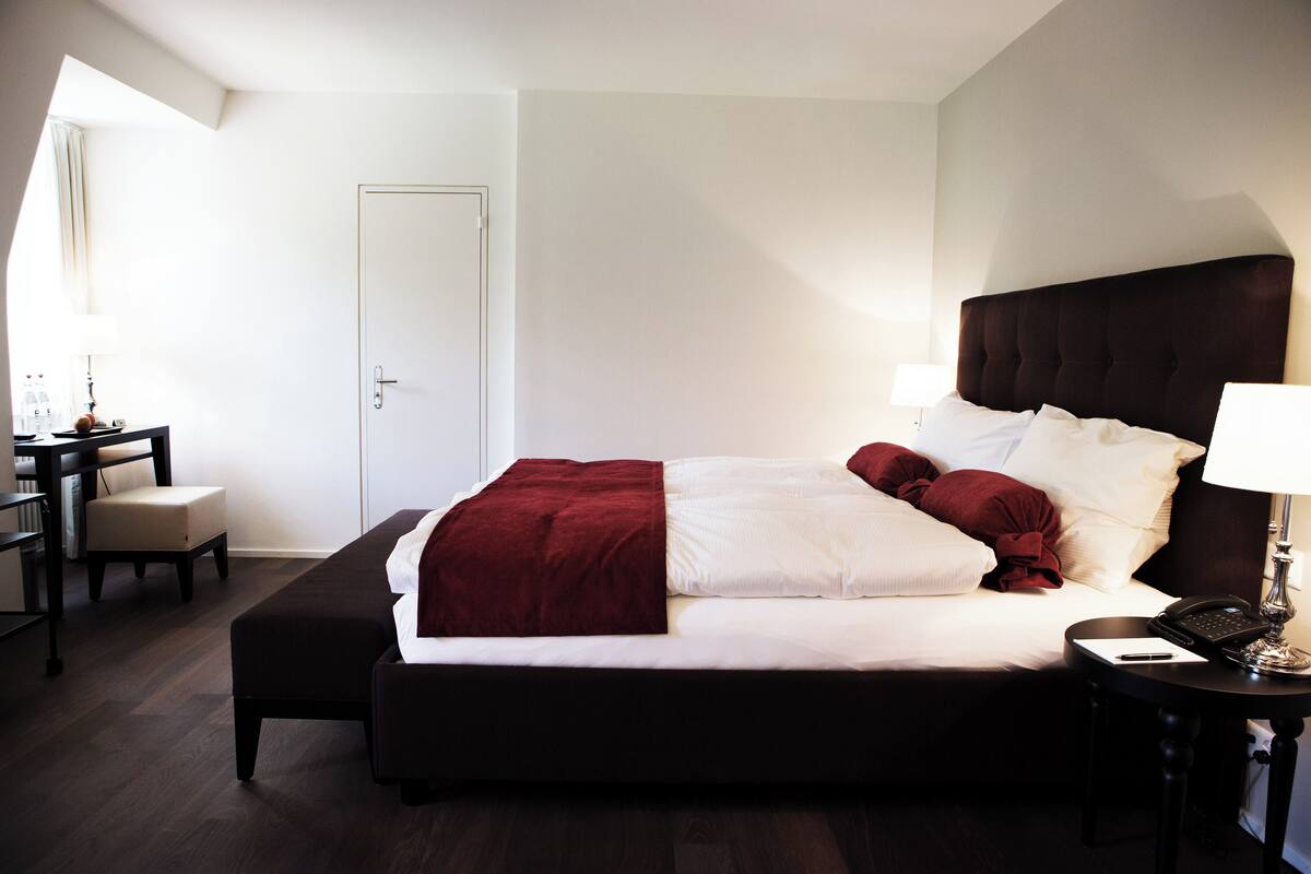 Una habitación de hotel con una cama grande, un escritorio y una silla.