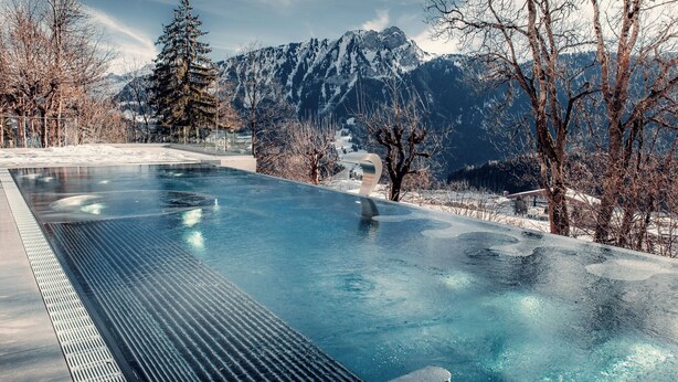 En swimmingpool med utsikt över snötäckta berg.