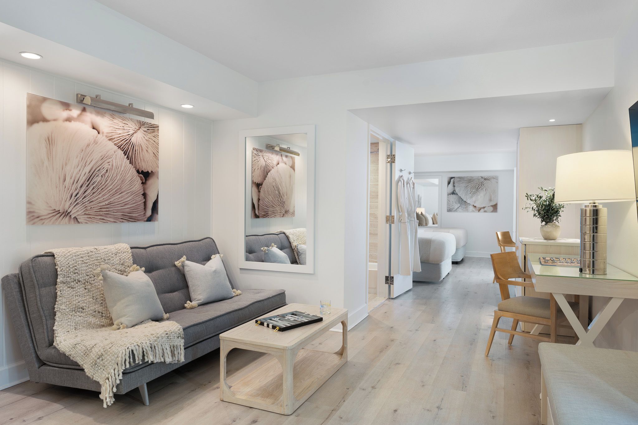 A modern living room with a grey sofa, a coffee table, and artwork on the walls.