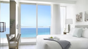 A hotel room with a large bed, a desk, and a view of the ocean. - Grand Beach Hotel Surfside (Surfside)