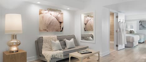 A modern living room with a grey sofa, a wooden coffee table, and a lamp.