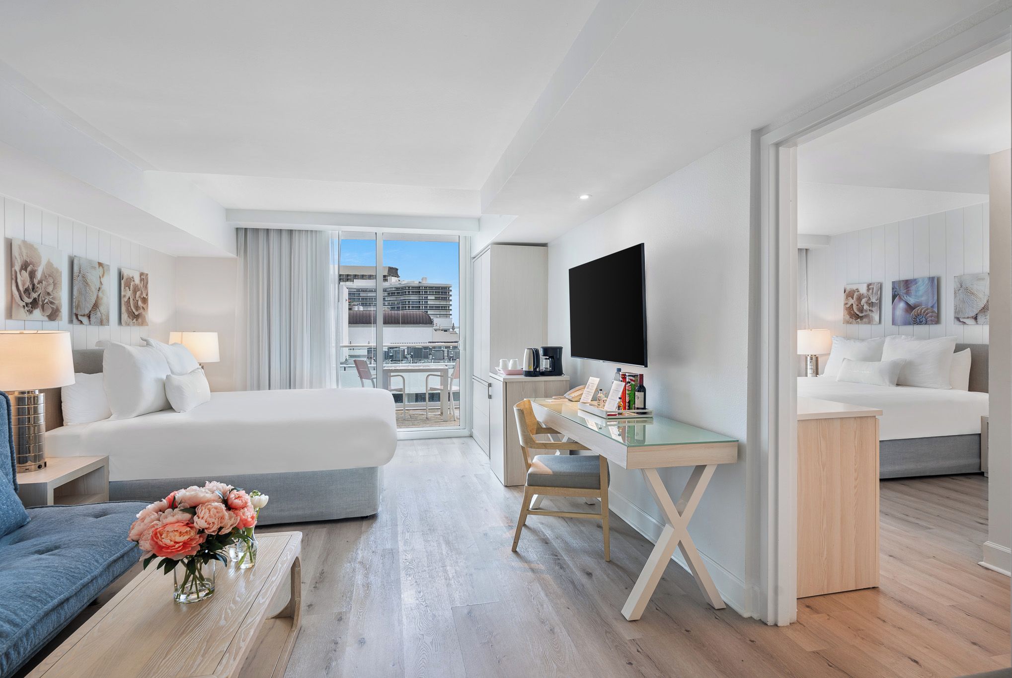 Una habitación de hotel con una cama, un escritorio, una silla, una cafetera y un televisor.