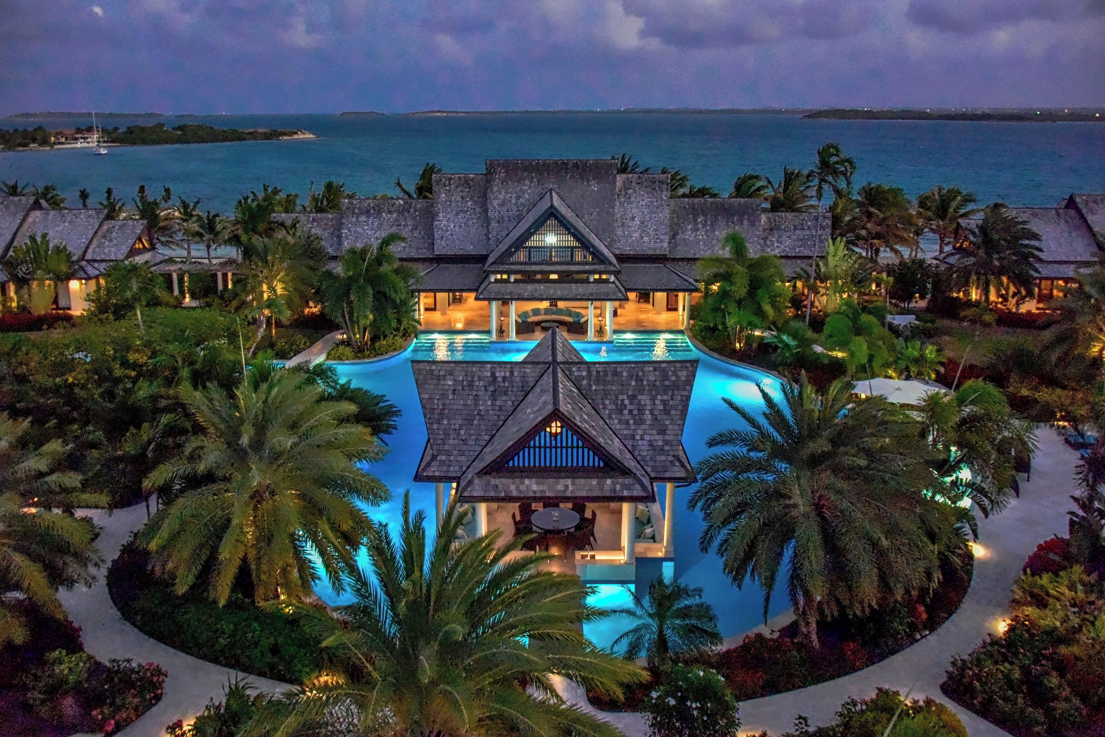 Ein Resort mit einem zentralen Pool, mehreren Gebäuden und Blick aufs Meer.