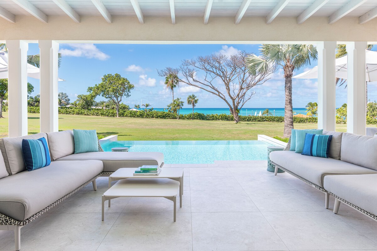 Ein überdachter Außenbereich mit Pool, zwei Sofas und einem Couchtisch.