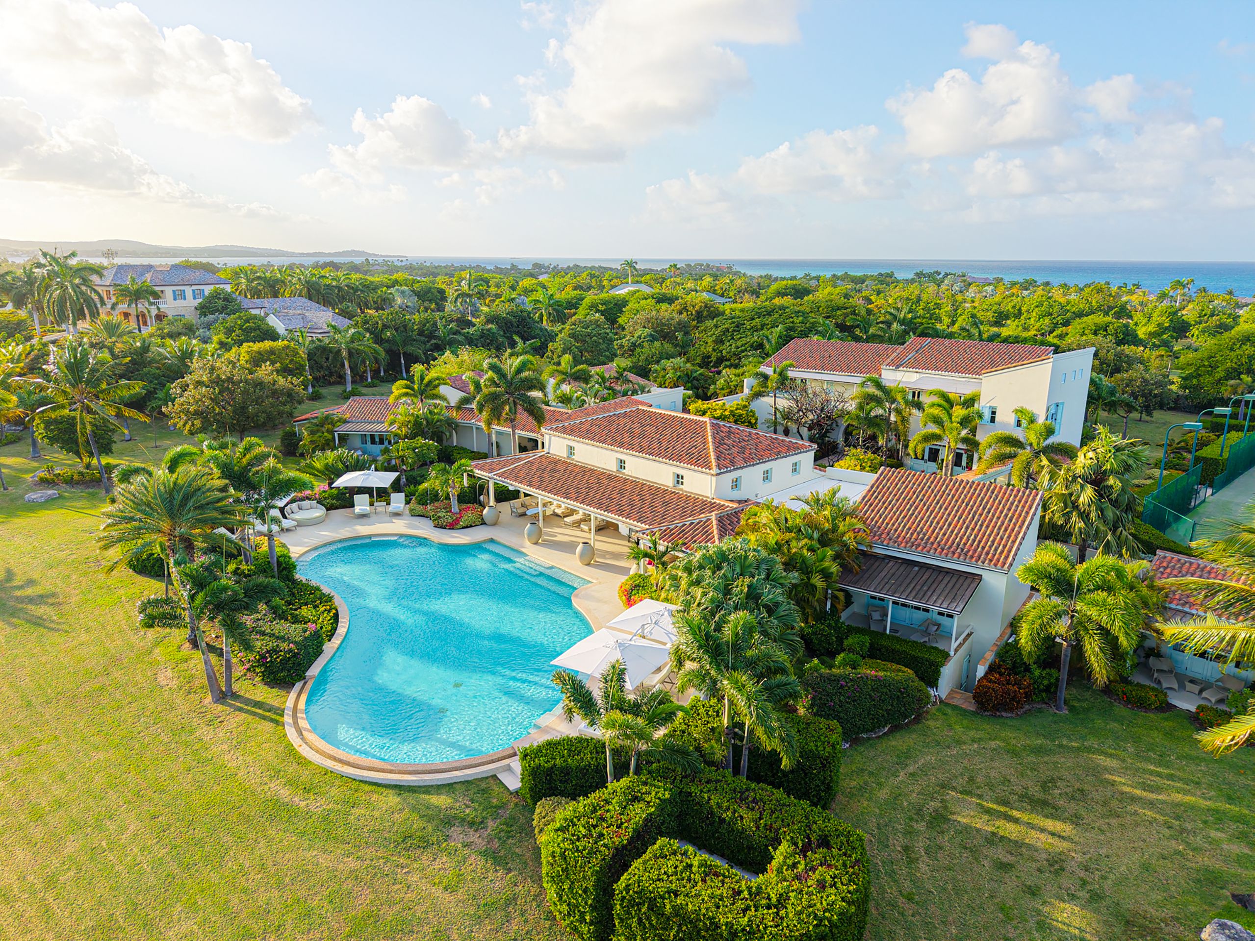 A resort with a swimming pool, multiple villas, and lush greenery.