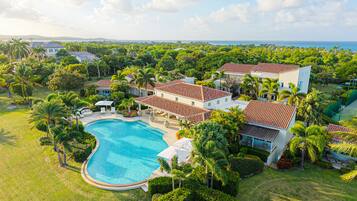 A resort with a swimming pool, multiple villas, and lush greenery.