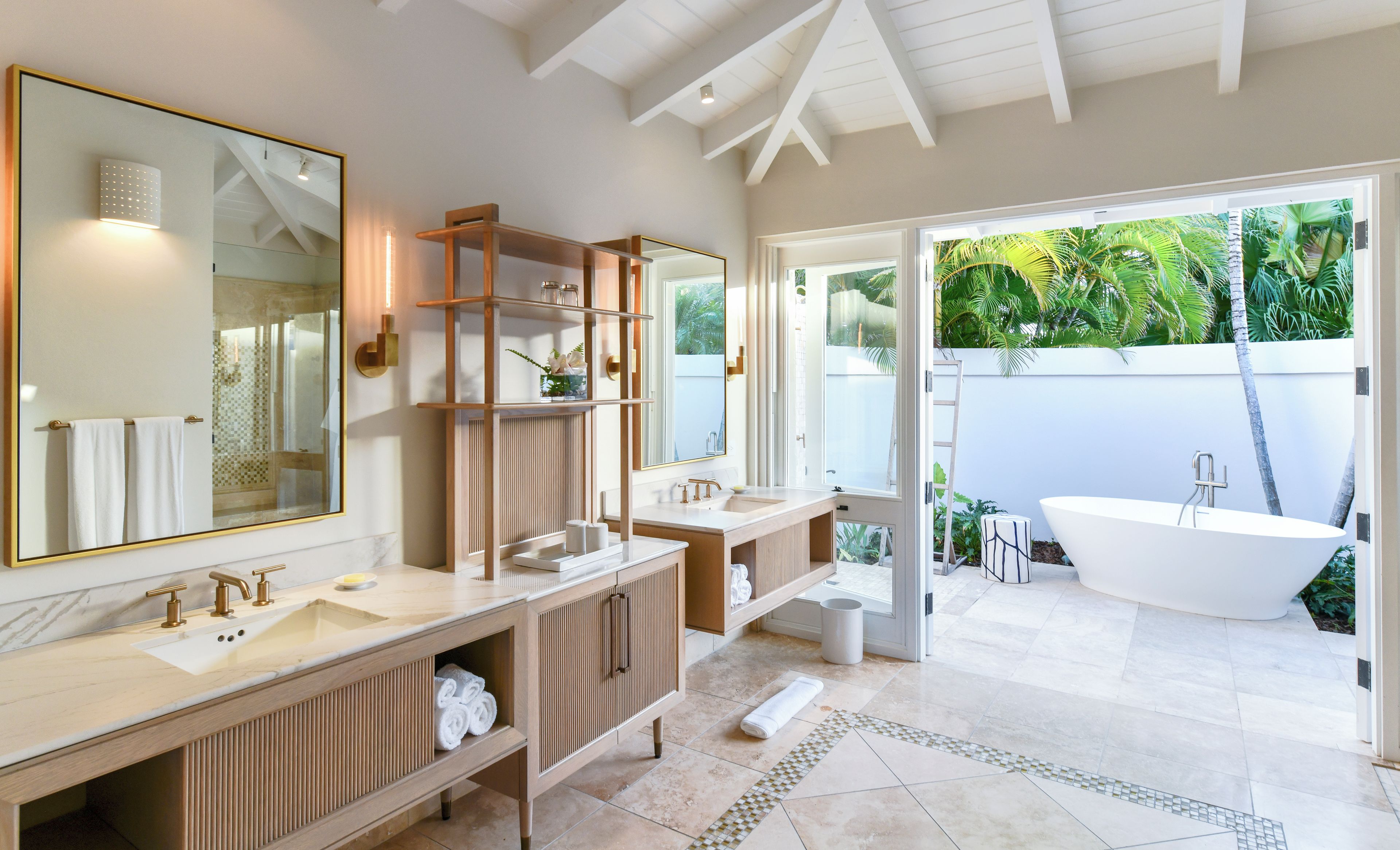 Un bagno moderno con due lavabi, uno specchio grande e una vasca da bagno.