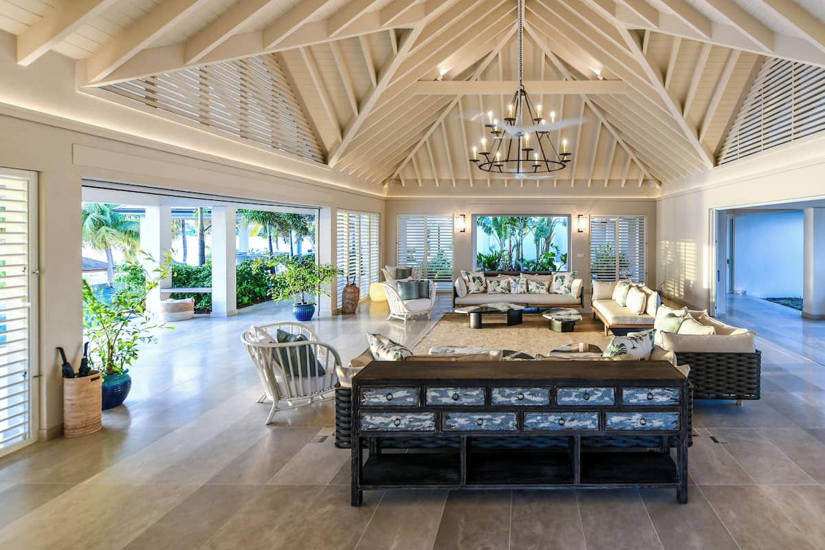 A spacious interior with a high ceiling, a central seating area, and large windows allowing natural light.
