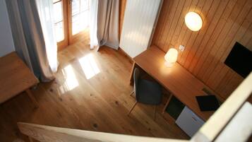 Una habitación con paneles de madera, un escritorio, una silla y una lámpara.