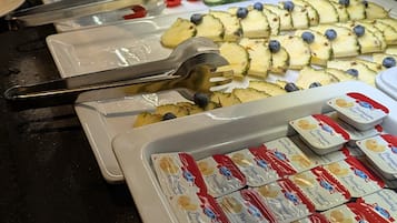 A buffet with various food items and condiments.