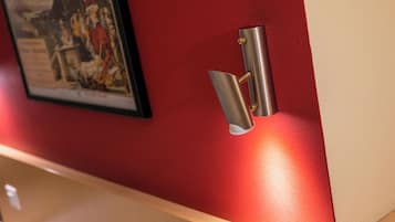 Una lámpara metálica fijada en una pared roja.